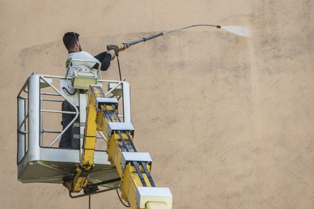 Bezdotyková aplikácie a čistenie fasády - Profesionál z Umyjemto umýva znečistenú fasádu za pomocou zvdihací plošiny